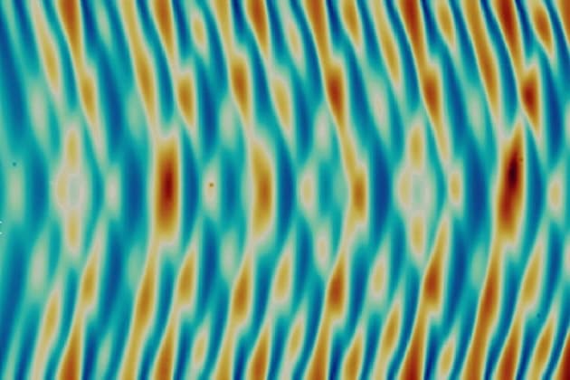 Surface pattern formation induced by oscillatory loading of frontally polymerized gels